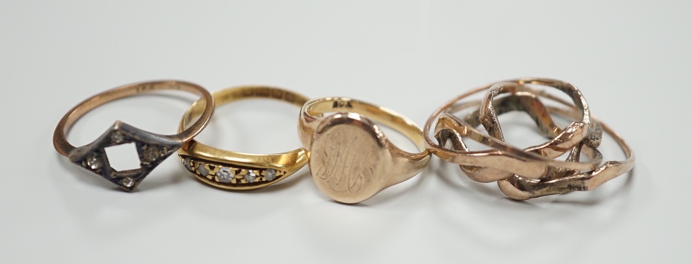 An 18ct gold and five stone diamond chip set ring, size L, gross 2.7 grams, two 9ct rings including small signet, gross 3.4 grams and a yellow metal puzzle ring.